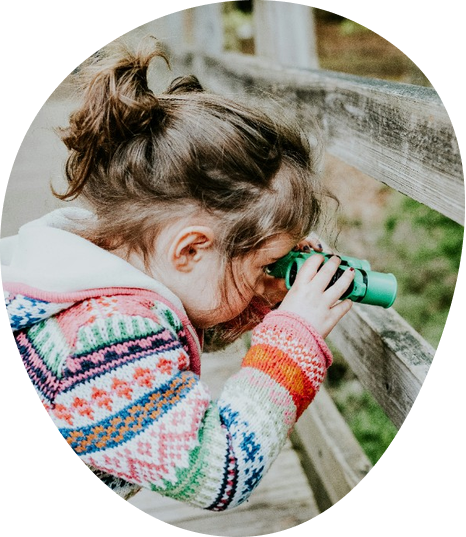 Child exploring outdoors with binoculars